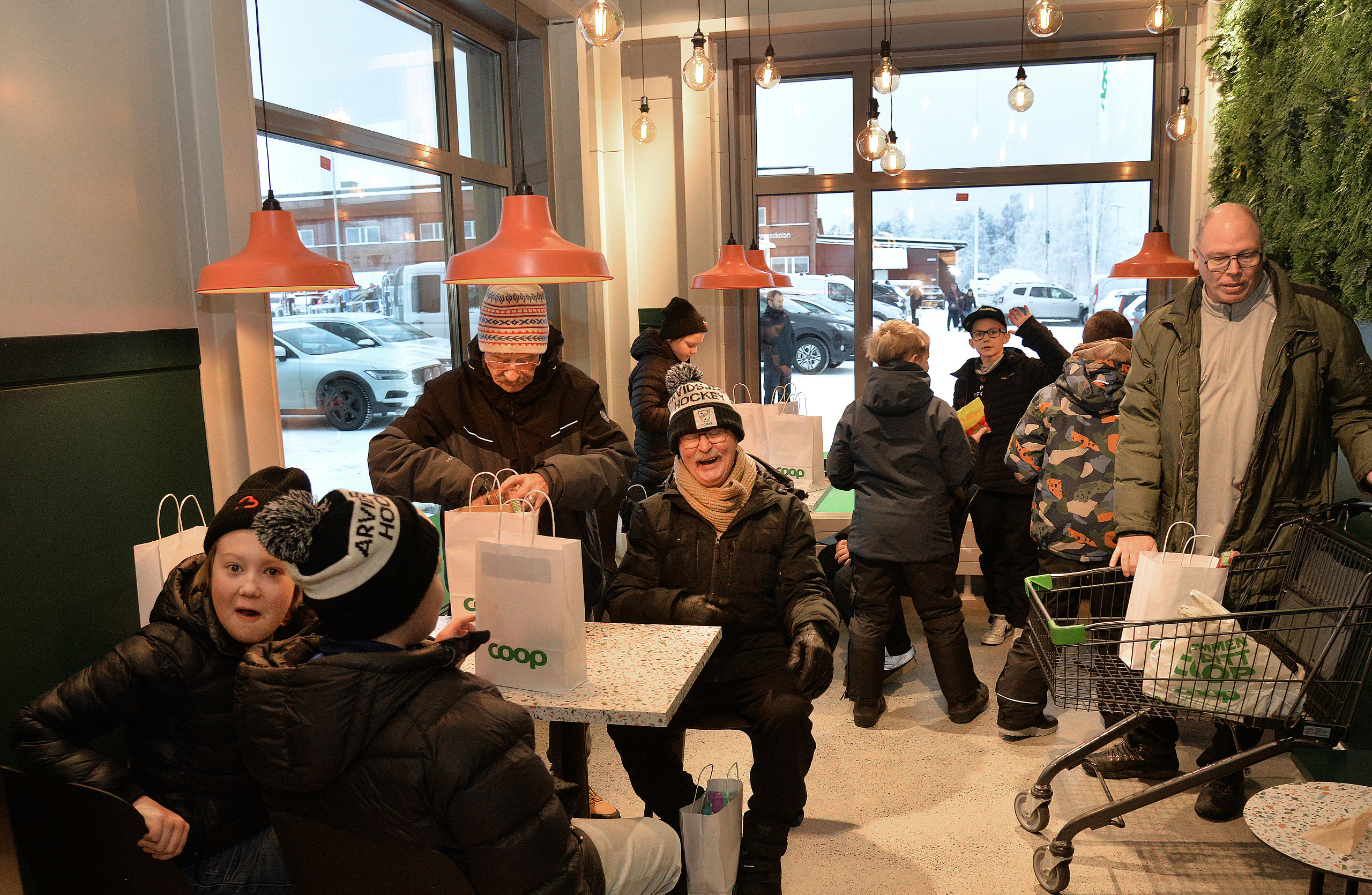 KAfé, 2025-11-22, Coops butikchef Ulf Isaksson, klippper invigningsbandet, och hälsar den långa kön välkommen in i nya butiken.