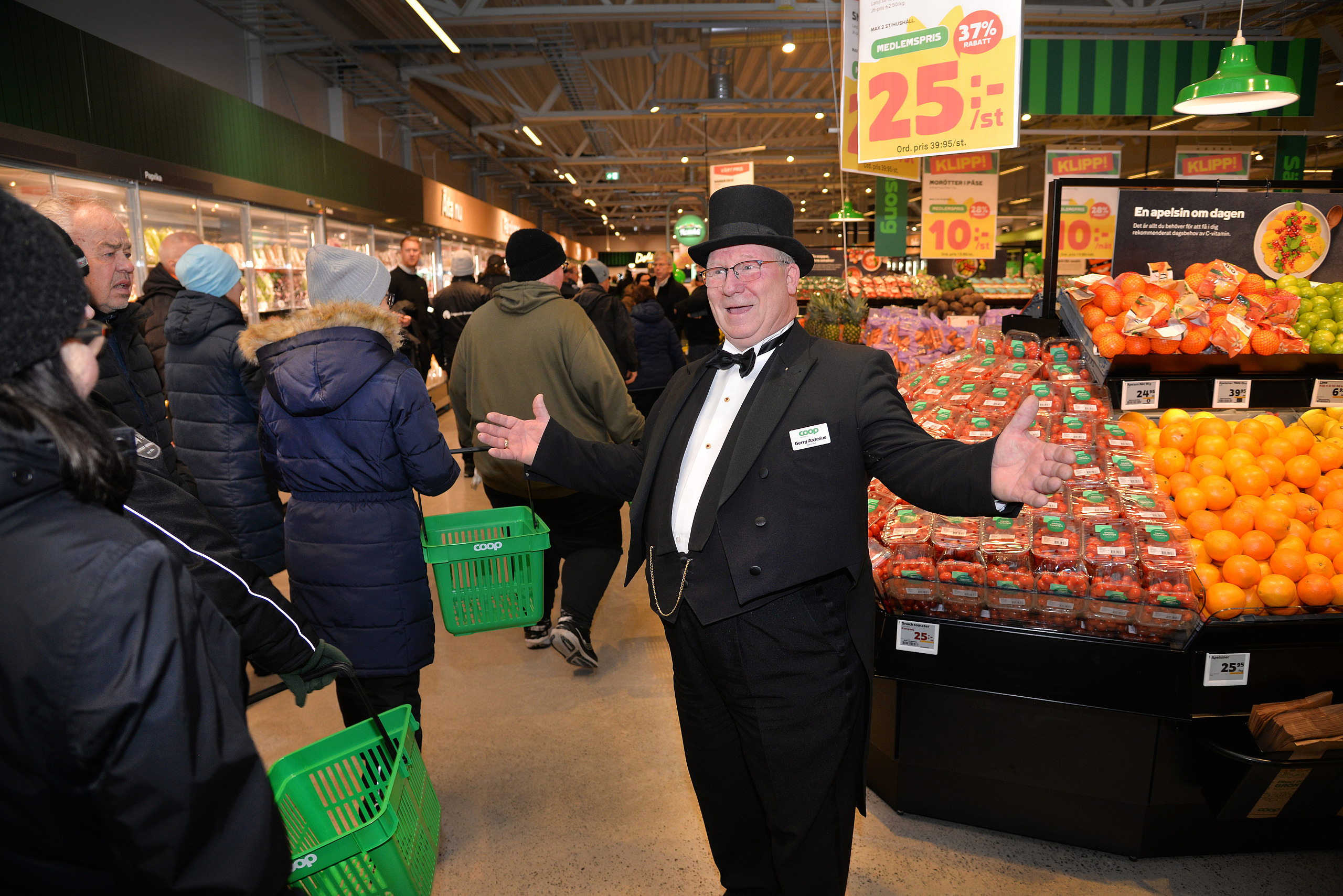Gerry Axtelius, tog emot i frack! 2025-11-22, Coops butikchef Ulf Isaksson, klippper invigningsbandet, och hälsar den långa kön välkommen in i nya butiken.