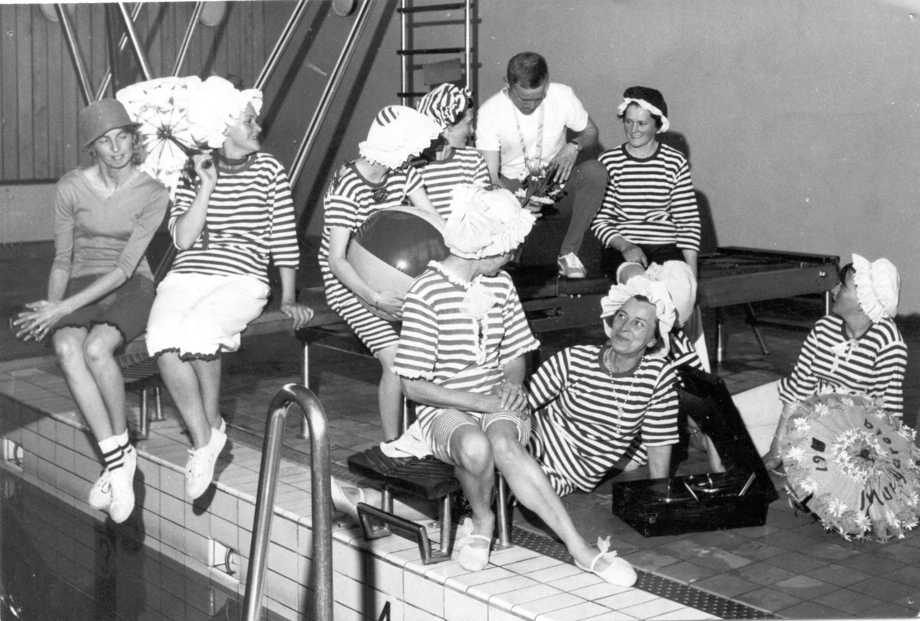 Arvidsjaurslottor, 1965 I baddräkter, badhuset, lottor Bakre raden från vänster: 1. ? Sundin 2. Lisa Wallin 3. Greta Larsson 4. Elly Danielsson 5. Sven Hellman 6. Sofia Åhman Främre raden: 7. Lisa Levén 8. Ingrid Vikström 9+10: De två längst till höger ej identifierade